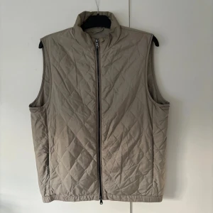 Oscar Jacobson väst - Sjukt snygg stilren och trendig beige Oscar Jacobson dunväst säljes. Väldigt eftertraktad och storleken är 52. Passar till allt och skicket är väldigt bra. Tveka inte vid minsta fråga eller fundering!