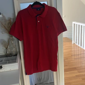 Röd pikétröja från Gant - Röd pikétröja från Gant med klassisk krage och två knappar framtill. Är min brorsas gamla och har inte blivit använd på ett tag.