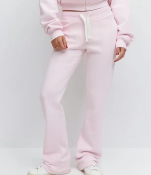 Ljusrosa mjukisbyxor med snörning - Ljusrosa mjukisbyxor med vit snörning i midjan och raka ben. Byxorna har bakfickor med broderad detalj och är tillverkade i mjukt material. Perfekta för en chill och avslappnad stil. Obs ett litet hål i sidan av ena benet skriv för bild 