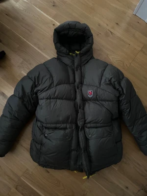 Fjällräven Expedition Jacka - Säljer en olivgrön dunjacka från Fjällräven (expedition) i storlek XS. Enda defekten är en liten rispa på ena armen, men påverkar ej användningen samt att den knappt syns. Väldigt fint skick