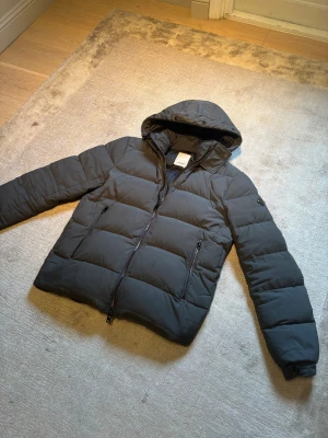 J.Lindeberg jacka - Säljer nu denna snygga J.Lindeberg jacka i storlek L. En perfekt vinterjacka för den kalla dagarna, jackan har en liten lappning på armen men den syns knappt, för frågor är det bara att höra av sig🙌