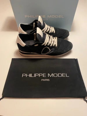 Philippe Model trainers - Säljer nu mina svarta Philippe model trainers i storlek 43 Med 🙌box och dustbag🙌. Dem är köpta förra vintern helt nya och bara använda av mig under förra vintern. Dem är i bra skick men med några små defekter pågrund av användning. Det har gått hål i båda innersulorna. Men innersulorna är fortfarande användbara och sköna. Skorna är i mocka med läder och textildetaljer. Det är en riktigt bra och skön vintersko. tveka inte på att höra av er vid frågor eller funderingar.