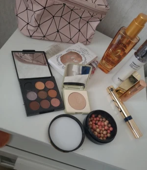 Sminkpaket med KIKO, Estée Lauder & palett - Säljer ett sminkpaket med KIKO Green Me highlighter i nyansen Champagne Gold, Estée Lauder Sumptuous Extreme mascara i guldig hylsa, ögonskuggspalett med varma och neutrala toner, rougepärlor i rosa och beige, samt två läppstift: ett rött i guldhylsa och ett nude i roséguld. Perfekt för dig som vill ha allt i ett. Sminkväska och lösnaglar.