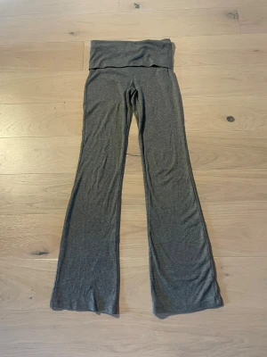 Youga pants - Supersköna grå Youga pants från Gina Tricot med bred, ribbad midja och bootcut ben. Byxorna har en fin passform och är gjorda i mjukt bomullsmaterial som är perfekt för chill dagar. Snygg enkel design som funkar till allt. Är använda typ två gånger.