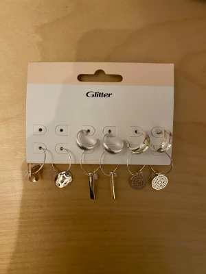 Flerpack örhängen från Glitter - Snyggt set med fem par örhängen från Glitter i silverfärg. Helt oanvända!