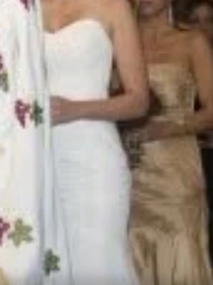 Vit axelbandslös bröllopsklänning  - Elegant vit axelbandslös långklänning med figurnära passform och hjärtformad urringning. Klänningen har en stilren design och passar perfekt till speciella tillfällen. Materialet ser ut att vara slätt och kan vara polyester eller liknande. Passar s ny pris 7000 behovs kemtvätt 