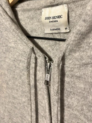 John Henric Kashmir - Säljer en grå John Henric zip up hoodie gjord utav 100% Kashmir. Den har blivit lite uppfräschad med nya beiga muddar som sitter på både ärmarna som ger en riktigt fräsch look. Vid noga inspektion finns det ett litet hål på tröjan, men det påverkar inte plaggets helhet. Nypris ligger på runt 3000kr vanligtvis och mitt pris är 649‼️Skriv vid minsta lilla fråga eller fundering✅