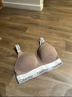🤎 Calvin Klein BH – ljusbrun, strl S 🤎 - Säljer en Calvin Klein BH i ljusbrun färg. Bekväm och stilren modell i mycket bra skick. Använd en gång och tvättad. Finns ingen stål tråd i själva bh-n. Nypris ca 350kr.  • Märke: Calvin Klein • Storlek: S eller 32A-B, 60cm runt om. • Färg: Ljusbrun • Skick: Mycket bra  Perfekt vardags-BH med snygg passform ✨