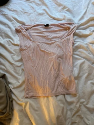 Ljusrosa ärmlös topp - Söt ljusrosa topp med bred urringning och ärmlös design. Tillverkad i mjukt material som känns skönt mot huden. Perfekt att styla med jeans eller kjol för en enkel och fräsch look.