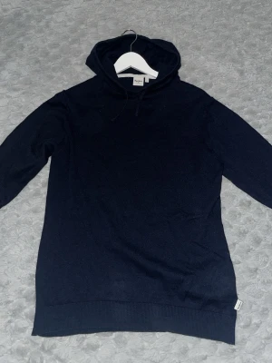 Mörkblå hoodie från Pepe Jeans - Snygg mörkblå hoodie från Pepe Jeans med klassisk huva och dragsko. Tillverkad i mjukt material som känns skönt mot huden. 