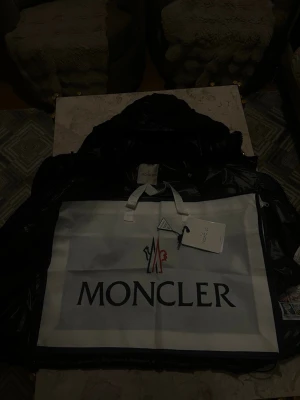 Svart Moncler dunjacka med huva - Snygg svart dunjacka från Moncler den är riktigt bra för kalla dagar. NFC fungerar också den här scann allt är som den ska helt ny. Priset kan diskuteras och om ni har frågor eller nånting skriv gärna.