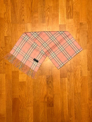 Rosa Burberry halsduk - Säljer en rosa halsduk från Burberry. Halsduken är i gott skick och är gjord i 100% kashmir. Var inte rädd för några frågor. Pris diskuteras inte!