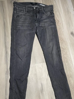 Replay anbass jeans W32/L32 - Snygga mörkgrå jeans från Replay i bra skick. Enda skavanken är lappen på sista bilden som är lite trasig men i helhet väldigt fina och bra skick. Storlek W32/L32 