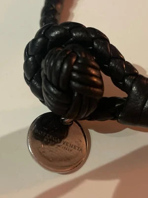 Bottega Veneta armband - Säljer mitt bottega veneta armband i jätte fint skick, lädret är i jätte fint skick men metallen har lite repor (se bild). Passar de flesta handleder och släpper absolut inte. Såklart är det 100% äkta (köper endast äkta (kolla tiktok @nomielis)). kontakta vid bud/frågor.