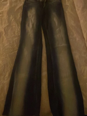 Blå wide jeans med slitningar - Snygga blå jeans med breda ben och slitna detaljer längs framsidan. Jeansen har en klassisk femficksmodell och är tillverkade i ett robust denimtyg. Perfekta för dig som gillar en avslappnad och trendig stil.