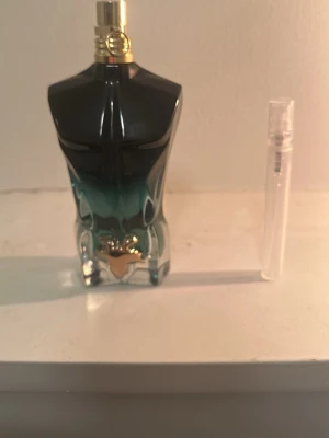 Jean Paul Gaultier Le Male parfym - Säljer en Jean Paul Gaultier Le Male parfym i en ikonisk flaska formad som en manlig torso. Flaskan har en snygg blågrön färgskiftning och gulddetaljer vid spraymunstycket. Perfekt för dig som gillar unika och stilrena dofter.