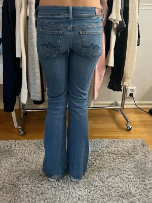 Lågmidjade bootcut Pepe jeans - Snygga blå bootcut jeans från Pepe jeans med klassisk femficksdesign och vågig brodyr på bakfickorna. Jeansen har en såå fin låg midja❤️Har lite slitningar längst ner på baksidan men är inget man tänker på❤️❤️