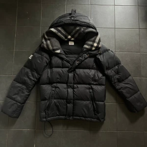 Burbarry puffer/väst  - Svart pufferjacka från Burberry med avtagbara ärmar, perfekt för vinter. Topp skick använd max 3 gånger. Pris kan diskuteras vid snabbt affär 