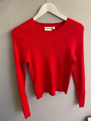 Röd tröja från Kappahl - Säljer en snygg röd ribbstickad tröja från Kappahl i storlek M. Tröjan har lång ärm, rund halsringning och en relativt tight passform. Jätteskönt material och perfekt inför julen❤️