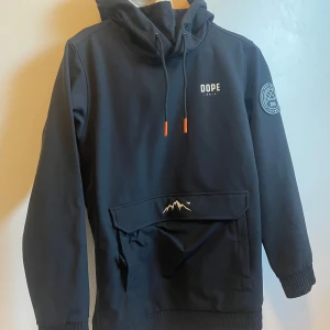 Svart hoodie från Dope med huva - Säljer en svart skidjacka från Dope med stor magficka⛷️🏂 Använd endast ett fåtal gånger så den är i riktigt bra skick👍🏻