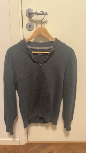 Mörkgrå tröja med half zip från Riley - Mörkgrå långärmad tröja från Riley med ribbade muddar och krage med half zip-dragkedja. Tröjan har en clean look och är gjord i mjukt bomullsmaterial, perfekt för lager-på-lager under höst och vinter. Testat haft på mig en gång och satt perfekt. Har dock inget som passar till det och gillar inte riktigt färgnyansen. 