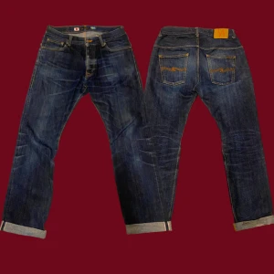 Nudie Jeans Selvage 2007 - Sjukt ovanliga Nudie Selvage Jeans. Första Nudie jeansen gjorda i Japan, släpptes under Inazuma Festival 2007. Japansk selvage med rött streck. Storlek 34/34" Model: Masa. Ca 112 cm längd, ca 43 cm midja, ca 87 cm innerbenslängd, ca 21 cm benslut. De är i riktigt fint skick, lite fades just nu men de kan utvecklas mycket. Liten slitning i vecket pga. att de varit uppvikta. Tveka inte på att meddela mig om ni har några funderingar.