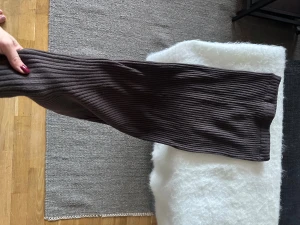 Brun stickad långkjol - Säljer en brun ribbad långkjol i tjockt stickat tyg. Inte alls genomskinlig och sitter snyggt. Använd ett fåtal gånger och i mycket fint skick. Står stl 38 i men motsvarar mer 36. 