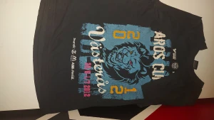 Aros Cupen Västerås t-shirt 2012 - Svart t-shirt från Aros Cupen Västerås 2012 med stor tryckt lejon-design i blått, vitt och gult på framsidan. T-shirten har korta ärmar, rund hals och är gjord i mjuk bomull. Tryck med turneringsdatum och sponsorer som McDonald's, ABB och Coca-Cola.