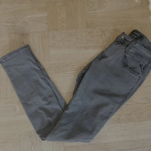 Raplay anbass hyperflex slim fit - Snygga grå jeans från Replay med klassisk femficksdesign och skinny passform. Jeansen har svarta detaljer vid fickorna och Replay-logga på både linning och myntficka. Tillverkade i stretchigt jeanstyg för en bekväm känsla.