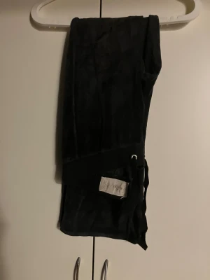 Svarta mjukisbyxor från Hollister - Svarta mjukisbyxor från Hollister med snörning i midjan. Klassisk relaxed fit och diskret logga på fickan. Perfekta för chill dagar eller när du vill vara extra bekväm.