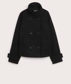 Svart skepparkavaj med knappar - Säljer en svart skepparkavaj med dubbelknäppning och höga slag. Jackan har breda manschetter med dekorativa knappar och en kort, boxig passform. Perfekt för dig som gillar klassisk stil med en modern twist. Materialet är tjockt och känns varmt. Nypris:999kr