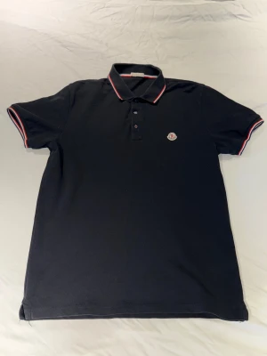 Moncler piké skjorta  - Svart Moncler Piké i top top skick. Använts några gånger bara men känner att jag inte riktigt har användning för den längre! Perfekt för dig som vill hålla garderoben uppdaterad över vintern!🤩