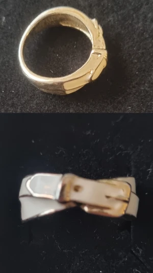 Guldfärgad ring med bältedetalj - Unik guldfärgad ring med coolt bältedetalj-design. Ringen har en blank finish och detaljer som liknar ett spänne, vilket ger den en edgy och modern vibe. Perfekt för dig som vill sticka ut med dina accessoarer.