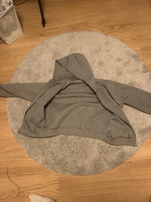 Grå weekday scuba zip up - Weekday Scuba zip (nypris 600 kr) med hel dragkedja framtill och huva. Tröjan har en loose passform och är tillverkad i mjuk bomullsmix. Långärmad modell med ribbade muddar och två fickor på sidorna. Perfekt för chill dagar eller när du vill ha något bekvämt.