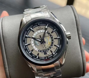 Omega Seamaster Aqua Terra Worldtimer - Omega Seamaster Aqua Terra Worldtimer med silverfärgat stålarmband och boett. Urtavlan har en världskarta i mitten och visar flera städer runt om i världen. Klockan har en automatisk rörelse och transparent baksida där mekanismen syns. Perfekt för dig som gillar detaljer och internationell vibe.