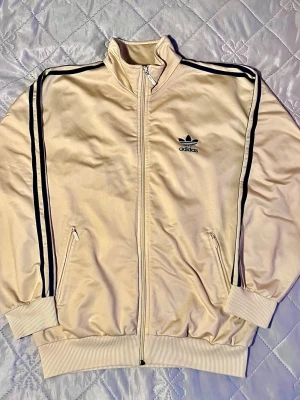Vintage Adidas 90s - Super sällsynt vintage Adidas-träningsjacka i elegant champagnefärg från ca 90-talet. I enastående fint skick. Storlek L.