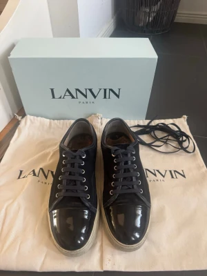Lanvin -  Marinblåa Lanvin skor uk 9 vilket motsvarar ca storlek 44 bra skick sulorna lite förstörda vid höken men funkar fortfarande perfekt använda några gånger kanske behöver en liten tvätt box skosnören två dustbags följer med