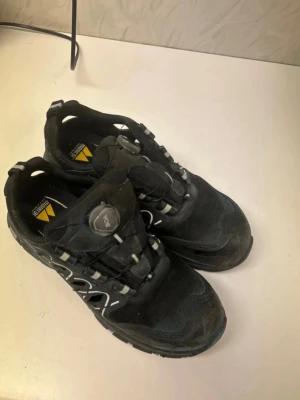 Monitor Robotic svarta sneakers strl 43 - Svarta sneakers från Monitor, modell Robotic, med BOA-snörning och grov sula för extra grepp. Skorna har vita och grå detaljer, ventilerande meshmaterial och förstärkt tå. Perfekt för dig som gillar robusta och funktionella skor med sportig look.