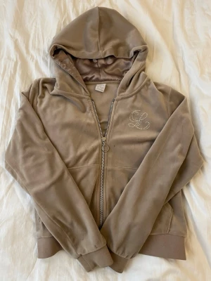Beige hoodie från Lindex - Fint beige sätt med byxor och tröja. Stl 146-152/12yrs. Inte använt många gånger. Finns ksk nån fläck men jag tvättar sättet innan det postas. Sättet är ifrån Lindex.