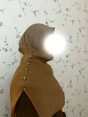 Brun stickad halskrage med knappar - Säljer en brun stickad halskrage med    snygga knappar längs ena . Tröjan har en loose passform och är perfekt för lager-på-lager under höst och vinter. Materialet är mjukt och ribbstickat, vilket gör den både bekväm och trendig.