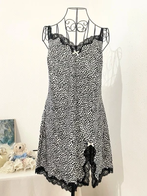 Svartvit leopardmönstrad nattlinne från Victoria's Secret - Supersöt nattlinne med svartvitt leopardmönster och spetsdetaljer i svart längs halsringning och nederkant. Storlek: L, passar 40-42. Dockans storlek: 34