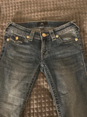 True Religion blå bootcut jeans - Snygga blå jeans från True Religion i modellen joey, strl 24! Passar nog om man har mindre eller större storlek då de är stretchiga, super bra skick😊