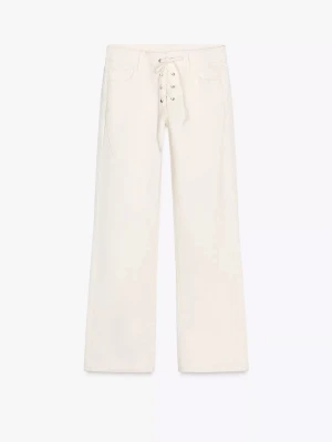 Vita jeans med snörning - Snygga vita jeans med snörning från Zara där tyvärr så är knappen där man ska stänga byxan borta men det går att ha på jeansen genom snörningen, det går nog att sätta dit en knapp!🥹men annars är de helt oanvända gott som nya. 