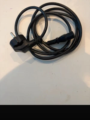 Strömkabel IEC C13 - Svart strömkabel med europeisk stickpropp och IEC C13-kontakt, perfekt för datorer, skärmar eller annan elektronik. Kabeln är i mycket bra skick utan synligt slitage eller skador. Längd ca 1,5 meter. Passar de flesta stationära datorer och bildskärmar.