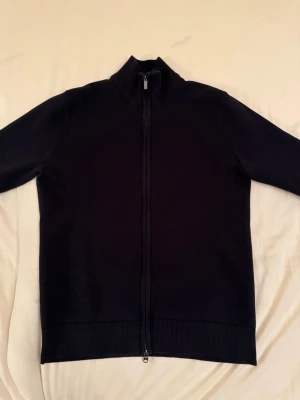 Bläck Zip Tröja - Snygg marinblå kofta från Bläck i storlek S. Modellen har hög krage, hel dragkedja framtill och är långärmad. Har en stilren look. Perfekt för lager-på-lager och passar till många olika outfits.