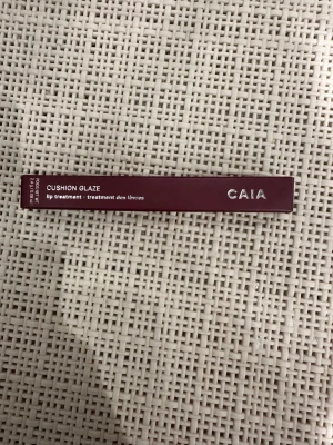 CAIA Cushion Glaze Plum Jam - CAIA Cushion Glaze lip treatment i färgen Plum Jam. Kommer i en stilren, vinröd förpackning med silvrig text. Produkten är tillverkad i Italien och innehåller 2,4 g. Perfekt för att ge läpparna en mjuk och glansig finish med en hint av plommonfärg. Enbart swatched på handen en gång