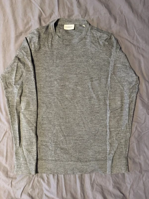 Tröja 50% merinoull Lindbergh M - Snygg grå tröja från Lindbergh White i storlek M. Tröjan har ett diskret broderat emblem på bröstet. Storlek M slim fit, den är i 50% merinoull. Tveka inte att ställa frågor! 💯