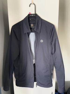 Henri Lloyd jacka - Snygg mörkblå jacka från Henri Lloyd. Jackan är i gott skick, endast några repor på knapparna som syns vid noggrann inspektion. Pris ej hugget i sten. Hör av er vid frågor!