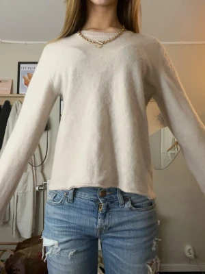 Beige/rosa stickad tröja  - Säljer en ljusbeige stickad tröja med rund hals och långa, lite vidare ärmar. Tröjan har en enkel och clean look, perfekt att styla med jeans eller kjol. Mjuk och skön kvalitet som känns lyxig mot huden.