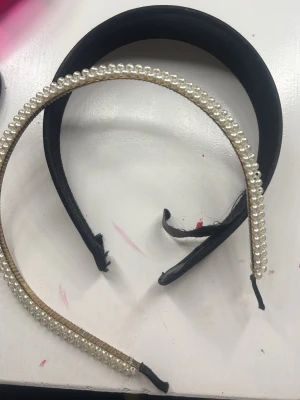 Pärlprydd smal håraccessoar - Smal håraccessoar med pärlor längs hela bågen. Färgen är vit med vita pärlor som ger en elegant och trendig look. Perfekt för att piffa upp frisyren och ge en söt touch till din stil.